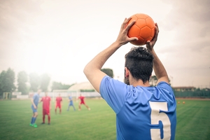 Football Player Throwing Ball to Teammate